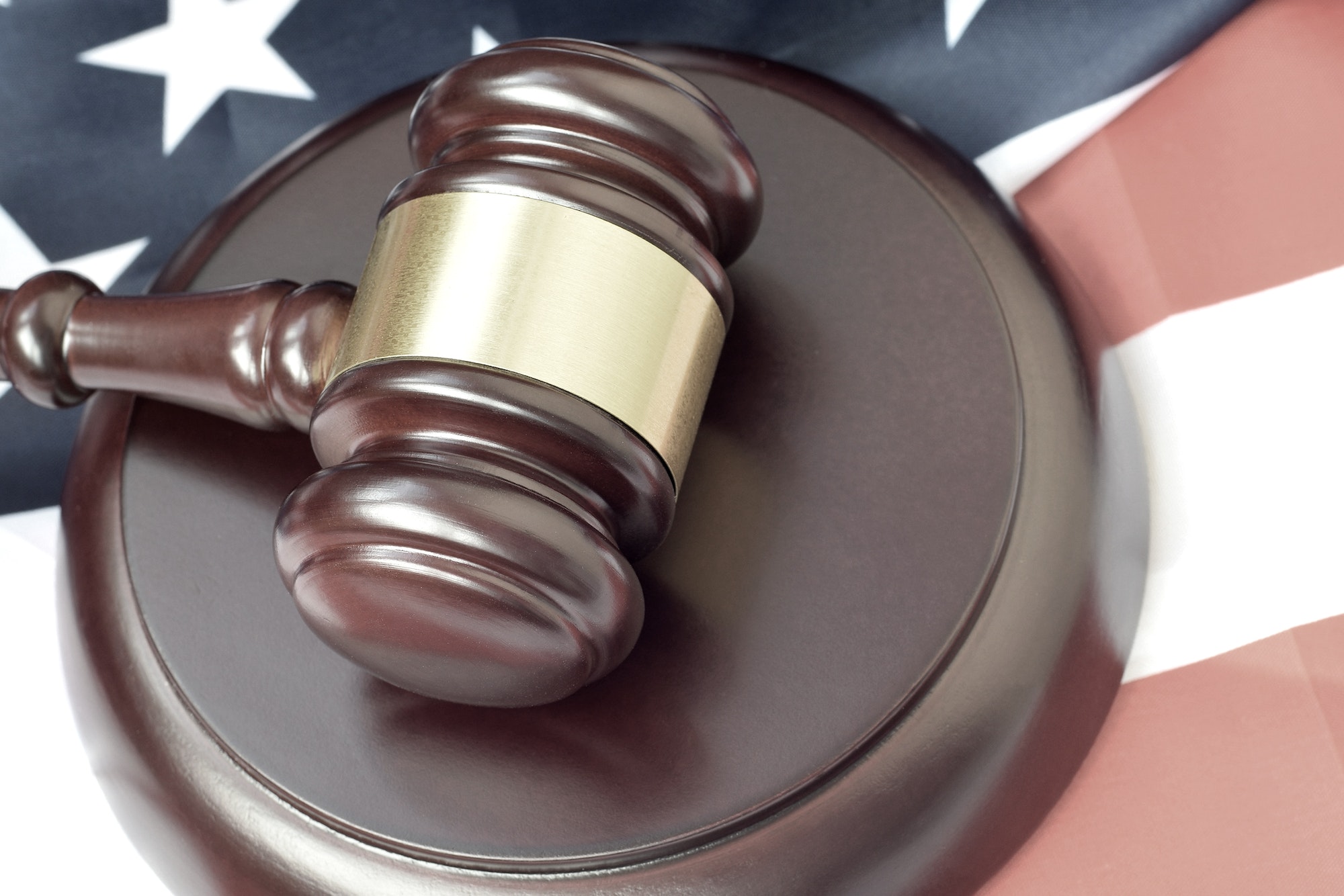 Justice mallet on United States flag in a courtroom during a judicial trial. Law concept and empty