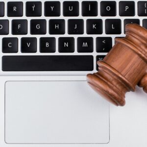 Laptop computer with legal court gavel on keyboard.