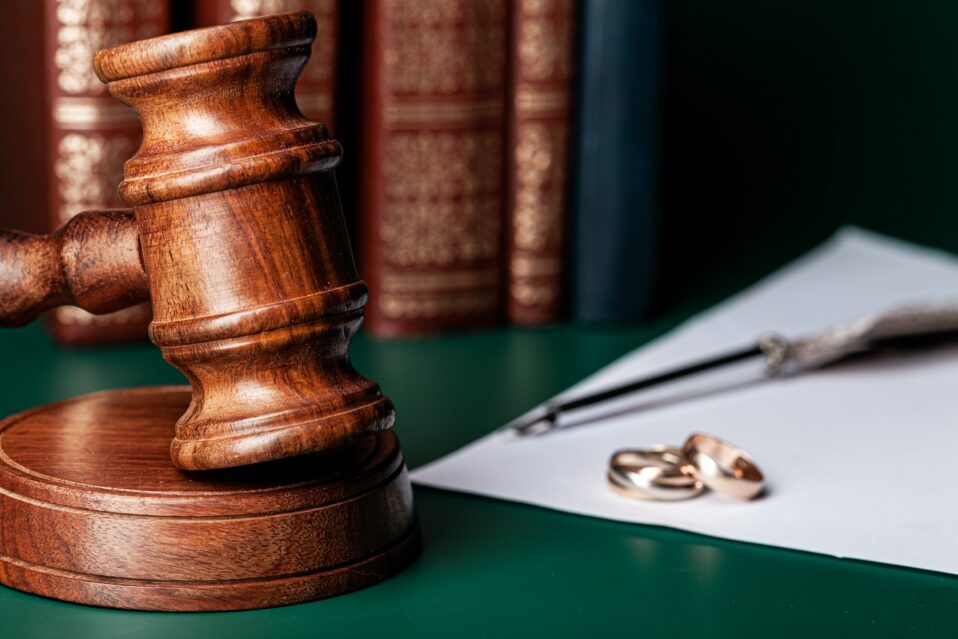 Law gavel and wedding rings on table