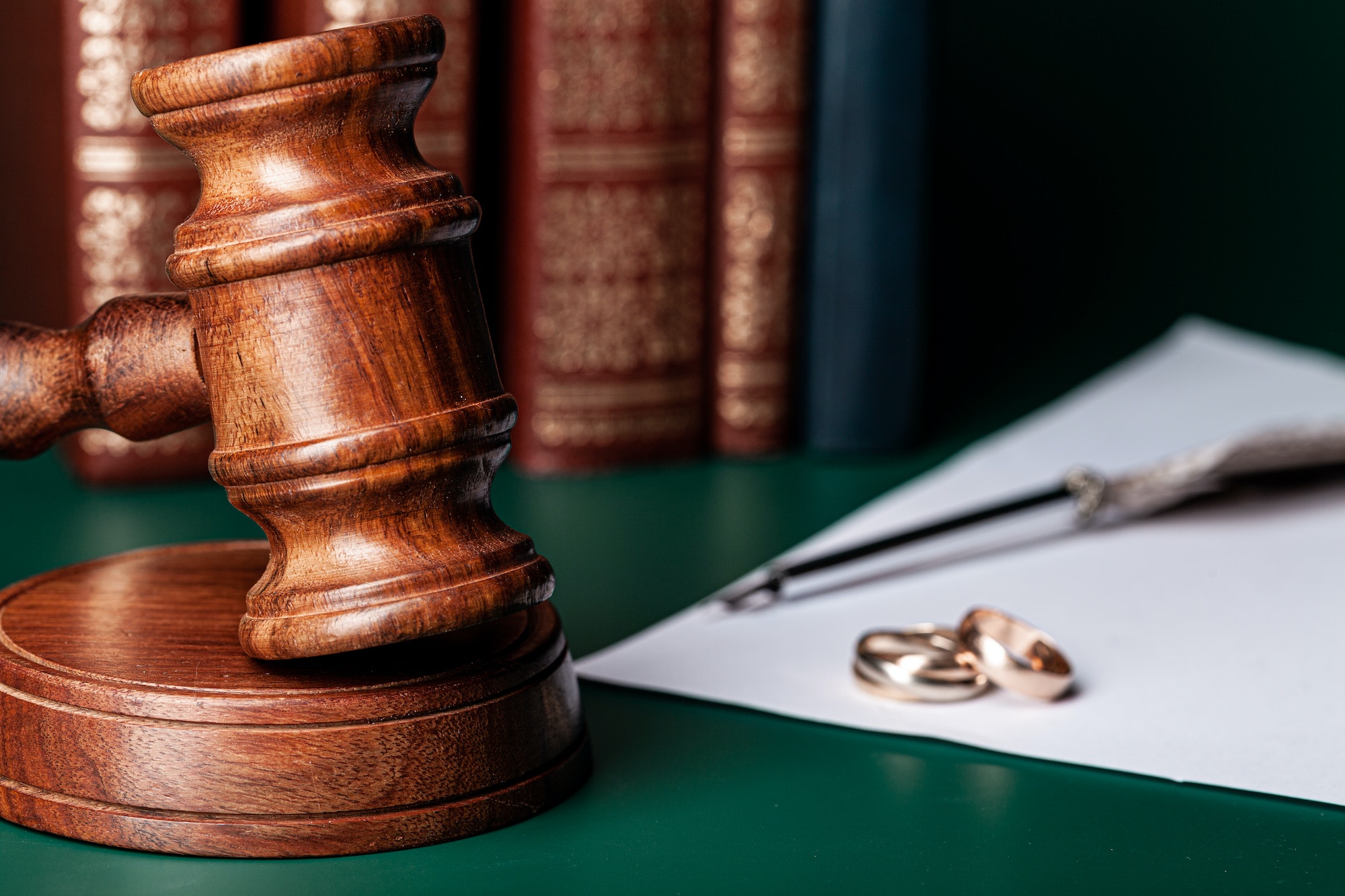 Law gavel and wedding rings on table